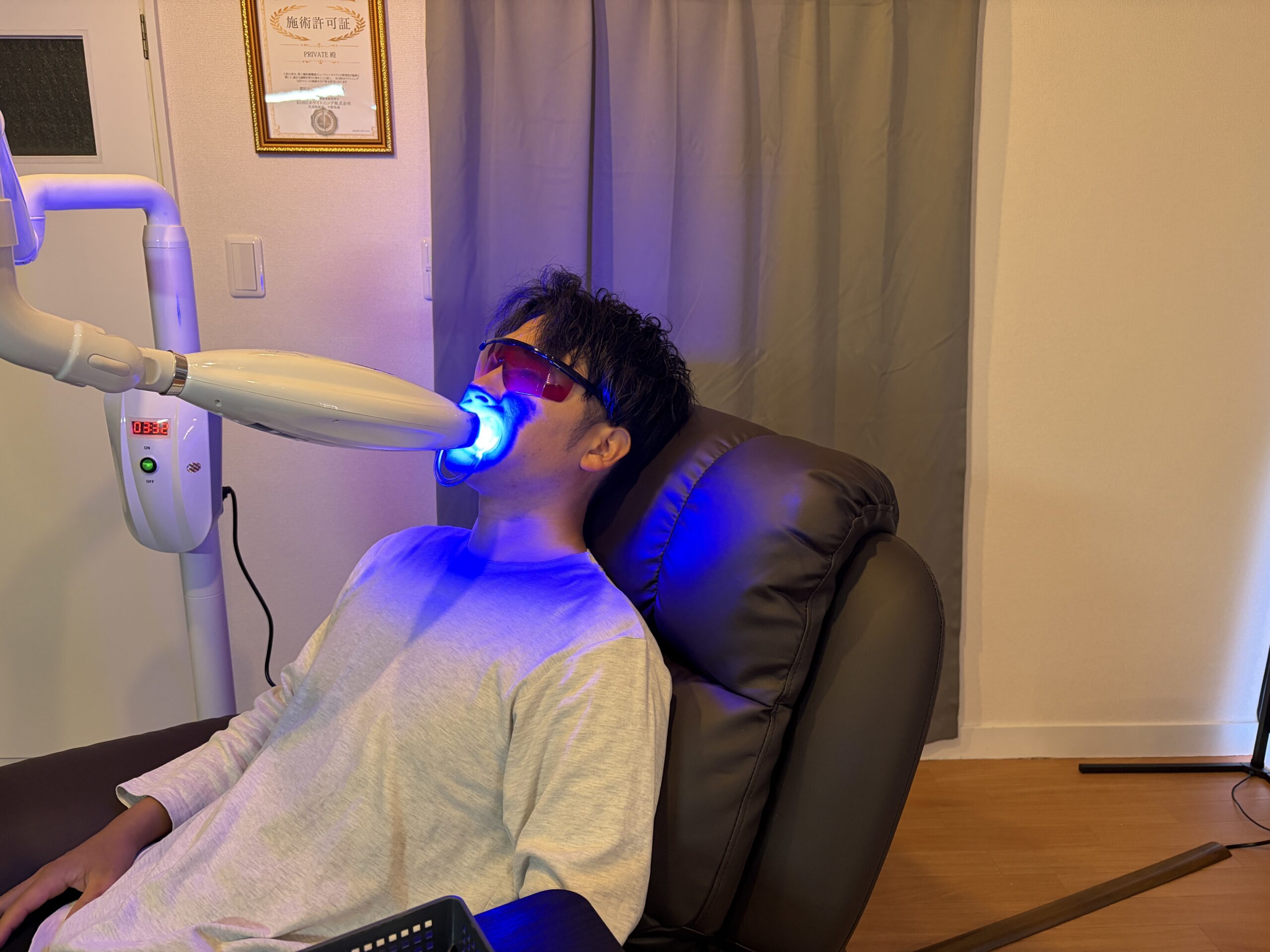 専用マウスピースとLED照射器を使用してセルフホワイトニングを受ける利用者の施術風景。
